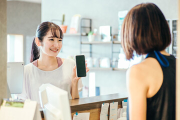 受付でスマホを出す女性
