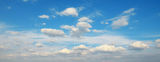 White fluffy clouds against bright azure sky.