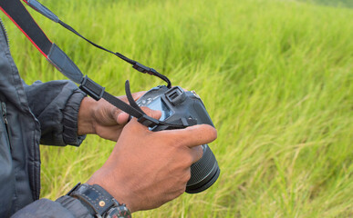 photographer checking his camera, young man checking his photo camera, close up of young man...
