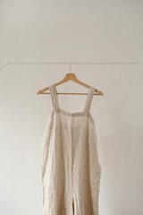 Women's aesthetic minimal fashion wardrobe concept with neutral pastel beige color overall dress or...