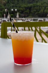 A glass of cocktail with crasheis in the summer by the pool, vacation concept