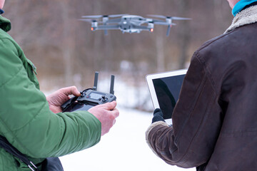 area planners survey the surroundings with a drone, hands with drone remote controller and a laptop