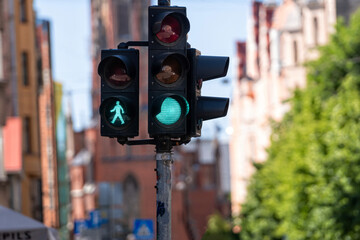 semaphore with green light in front of  defocused street backdrop