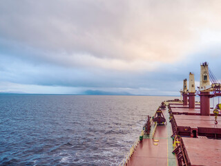 General cargo vessel at sea, deck view to a cloudy sky. Marine delivery and shipping at any weather...