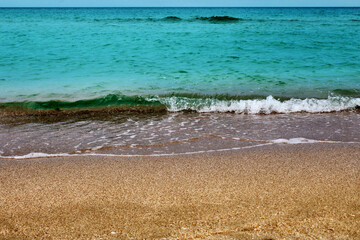 Blue sea wave on a pebble beach.