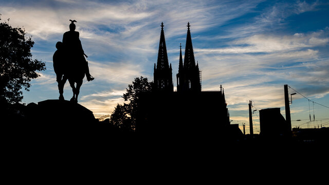 Black silhouette of Cologne Cathedral and Kaiser Wilhelm II equestrian statue. .