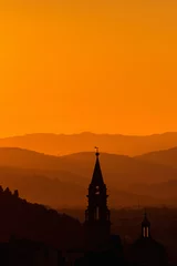 Fotobehang Kerktoren in het zonsondergangsilhouet met bergen op de achtergrond © Lars Johansson