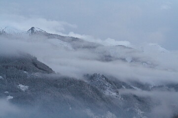 Fototapeta na wymiar nebbia su montagne innevate