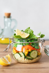 Glass jar with fresh raw vegetables and couscous groats. Healthy Meal Prep - recipe preparation photos. Healthy vegan dishes in glass containers. Weight loss food concept. Salad in a jar.