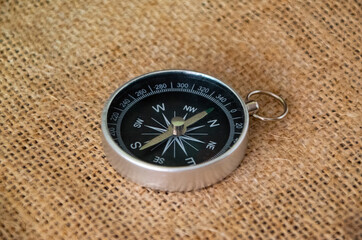 Compass on burlap. Geographical background close-up. Tourism, geography, path, direction
