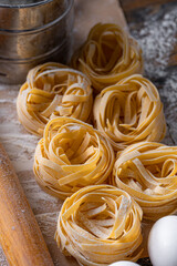 Homemade fettuccine pasta folded in the shape of a nest. Home cooking with ingredients for homemade traditional Italian fettuccine pasta.