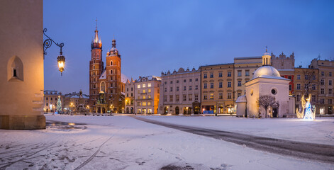 Krakow, Poland, snowy winter Main Square night panoramic view with St Mary's church