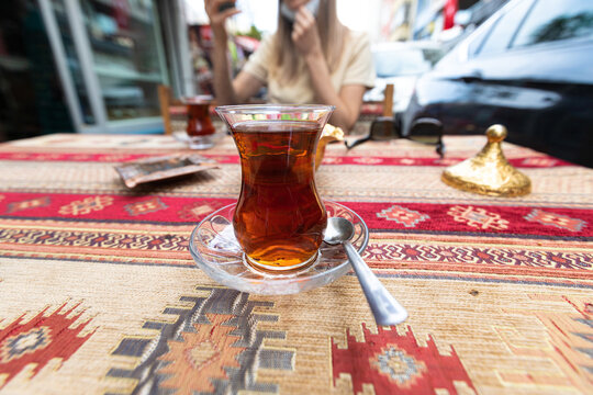 Traditional turkish tea in tulip-shaped glass called ince bellicup on the table of cafe in the historical center of Istanbul. Shallow DOF.