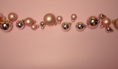 Christmas balls of different sizes on a pink background. festive decoration