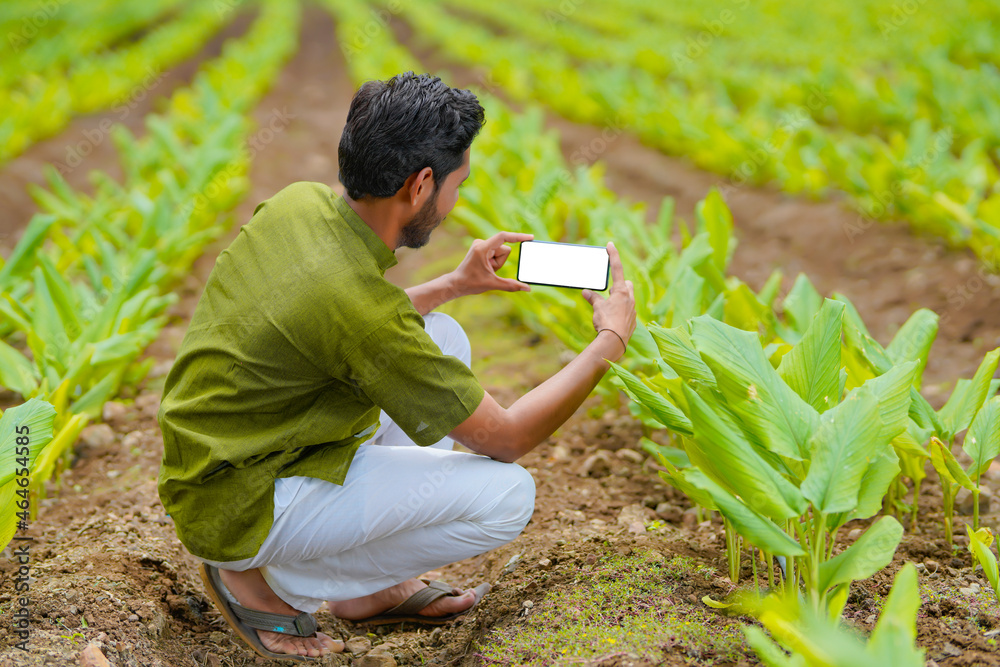 Poster Indian farmer using smartphone at agriculture field