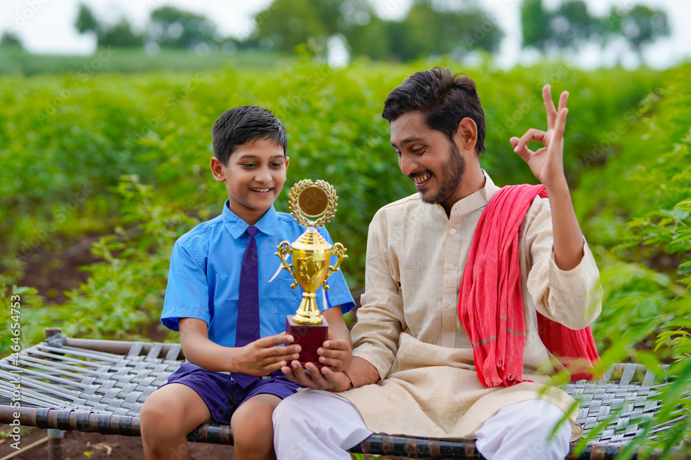 Poster clever school boy holding winning trophy and celebrate with his father.