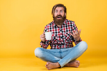 surprised handsome bearded guy with unshaven face and stylish hairdo wear casual clothes drink...