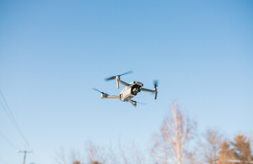 The drone is flying over the ground in a cloudy blue sky. taking pictures from the sky