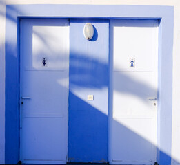 bathroom doors. white and light blue. man and woman.