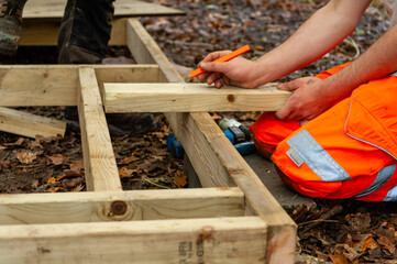 carpenter penciling in a cut to be made on wood
