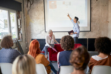 A young man is holding a presentation for his colleagues in the office
