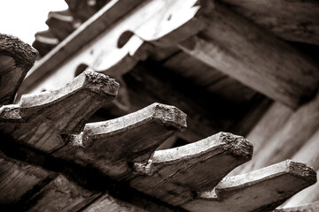part of the roof of the building. wooden building. black and white photo. the building is made of wood. close-up