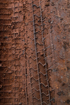Tire imprint in mud close-up with artistic conotation like a contemporary art painting, tire track in mud, dirt texture with tire mark