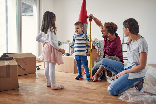 beautiful young family having fun, playing in new apartment, still unpacked