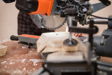 a carpenter Saws furniture parts with a circular saw. Tinted image. to close. circular saw for...