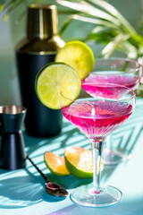 A pair of cocktail glasses with campari decorated with lime slices.