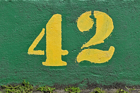 Number 42 painted in yellow on a green wall