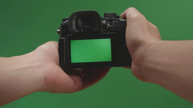 Male Hands Taking Photos With Green Screen Display Camera In Green Background
