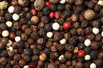A mixture of peppercorns as a textural background in full screen.