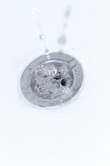 A stream of water flowing down the drain in the sink