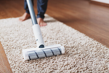 A white turbo brush of a cordless vacuum cleaner on the carpet. Indoor cleaning concept