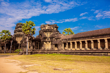 Fototapeta na wymiar The ancient city of Angkor Wat in Cambodia. Towers of the temple of the Kmer people streets and ruins of houses. Traveling to the sights of ancient civilizations. Stone bas-reliefs on the ruins.