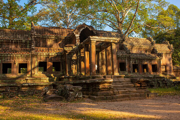 Fototapeta premium The ancient city of Angkor Wat in Cambodia. Towers of the temple of the Kmer people streets and ruins of houses. Traveling to the sights of ancient civilizations. Stone bas-reliefs on the ruins.