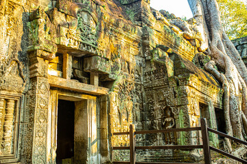 Fototapeta premium The ancient city of Angkor Wat in Cambodia. Towers of the temple of the Kmer people streets and ruins of houses. Traveling to the sights of ancient civilizations. Stone bas-reliefs on the ruins.
