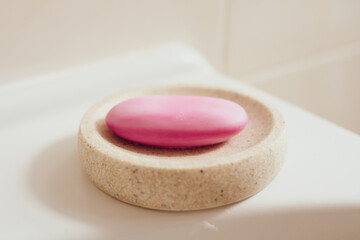 Pink soap in a soap dish in the bathroom. Hygiene and cleanliness concept