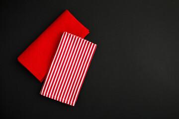 Top view of red and striped napkin on the black background. Copy space. Close-up.