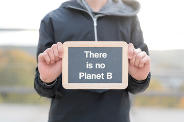 Schüler oder Jugendlicher mit einer Tafel auf der There is no Planet B steht