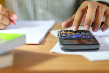 close up hand man doing finance and calculate about cost.