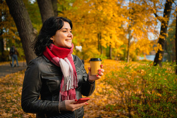 Fototapeta na wymiar girl walking in autumn park with a cup of coffee