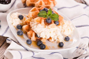 Waffles with blueberries and whipped cream.