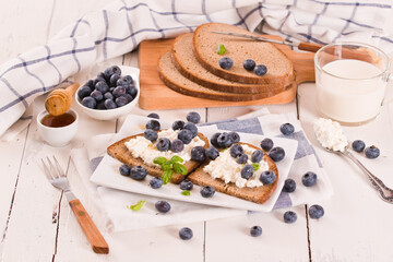 Rye bread with cottage cheese, blueberries and honey.