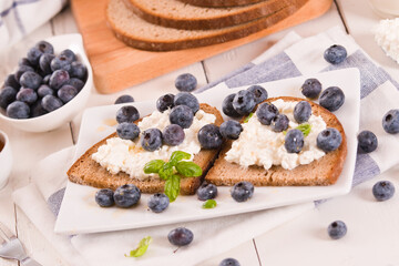 Rye bread with cottage cheese, blueberries and honey.