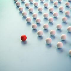 Leadership Concept: A group of white spheres with one sphere in red leading the group.