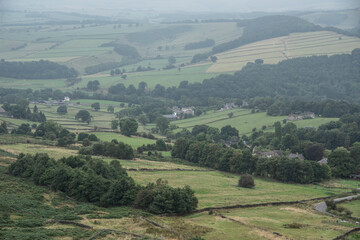 Lovely landscape image of a small village in the Peak District National Park on a misty morning in the English countryside