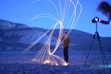 Iron wool circle drawing light fireworks. Burning Steel Wool spinning, Trajectories of burning sparks at night. Movement light effect, steel wool fire hoop. long exposure light painting, Pyrotechnic