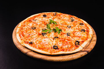 Pizza with olives and tomatoes on a wooden board on a black background